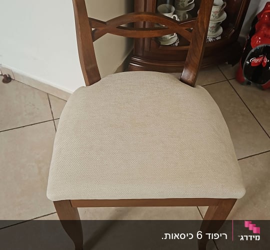 כיסא עץ עם ריפוד בהיר על רצפת אריחים